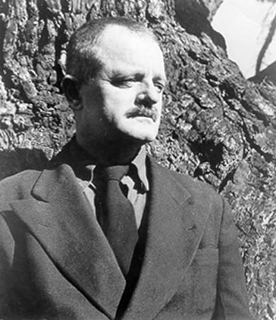 Kenneth Rexroth in suit at tree